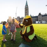 Parka kneels as she gives a high five to kids on Parliament Hill.