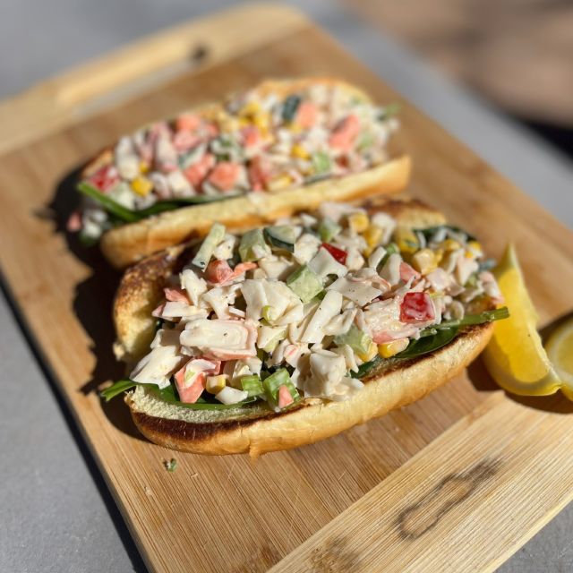 Assembled sandwich rolls arranged on a wooden cutting board.