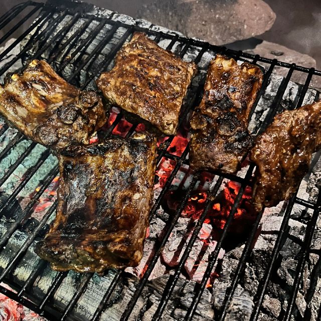 Ribs on the grill, caramelized and slightly charred.