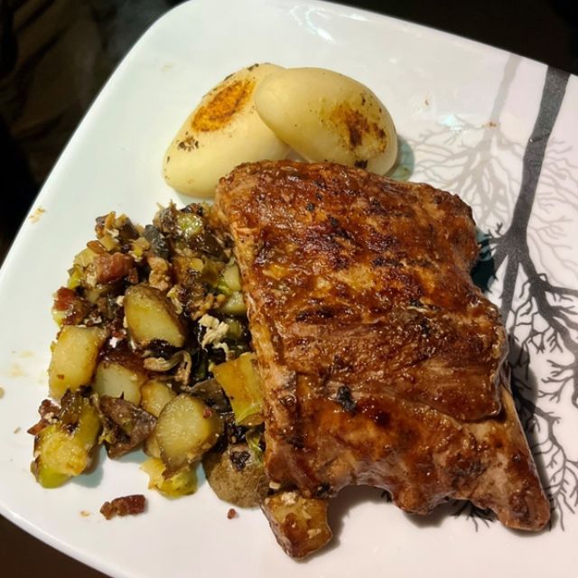 Cooked ribs served on a plate with potatoes.