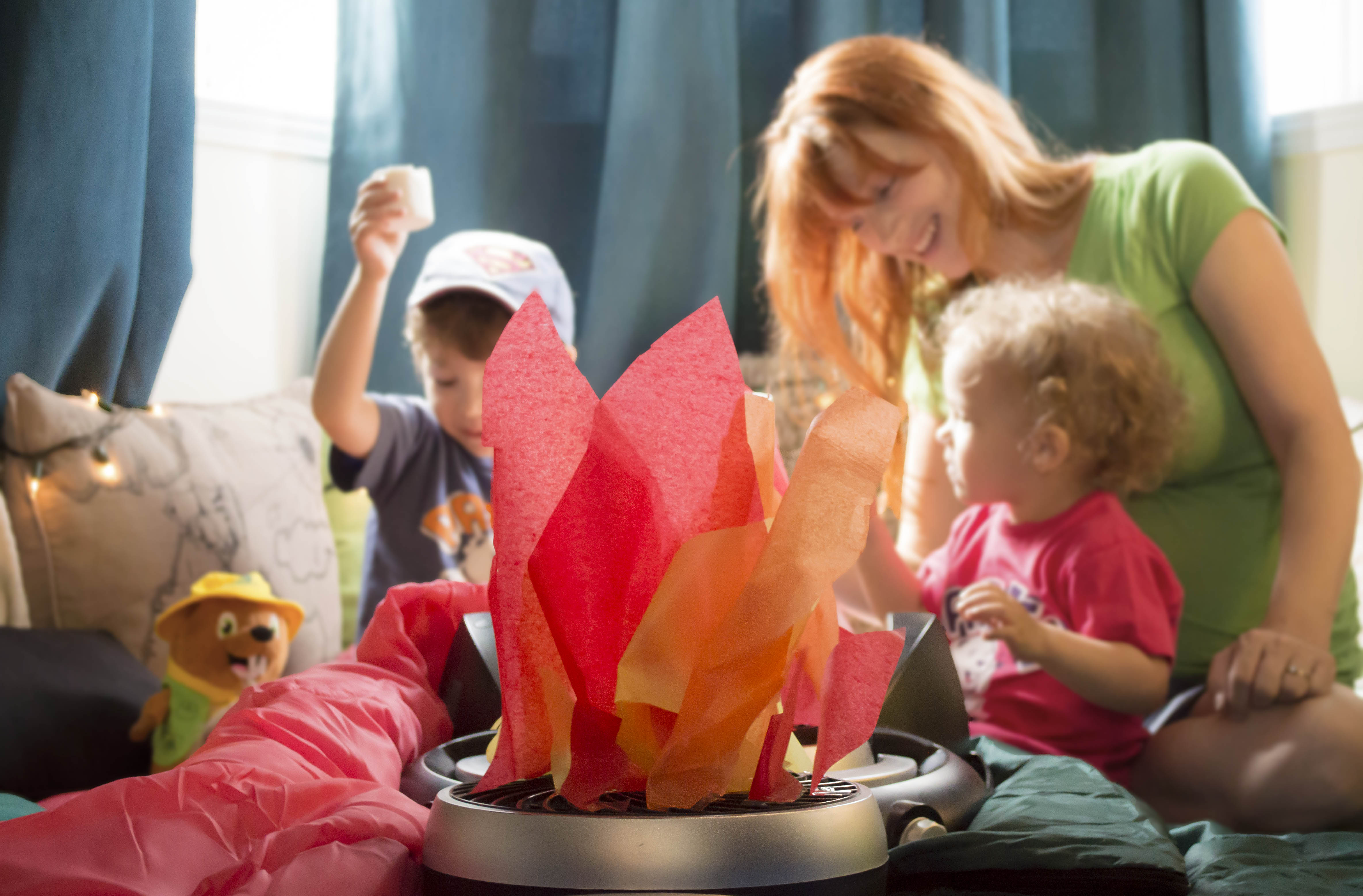 Une famille autour d’un bricolage de feu en papier de soie.