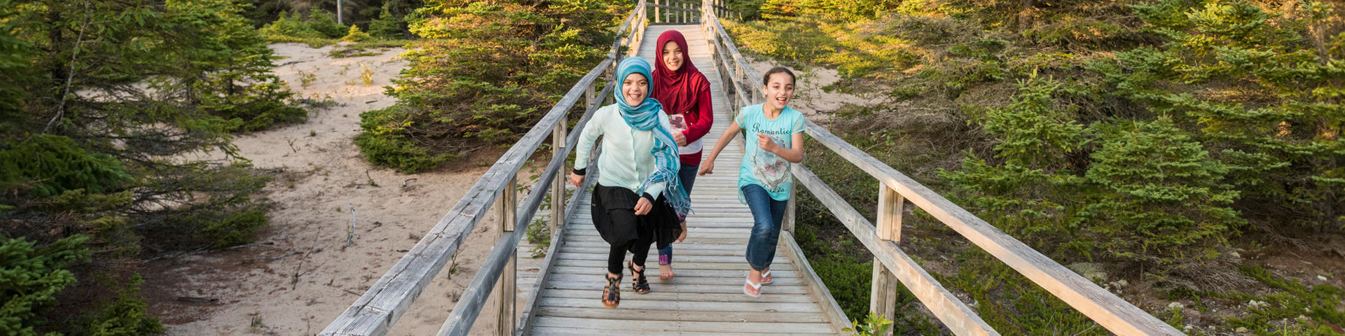 Famille marchant sur une promenade entourée d'arbres au parc national Pukaskwa.