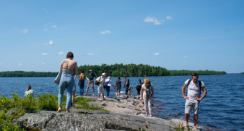 Un guide de Parcs Canada conduit les visiteurs vers les pétroglyphes sur les rives du lac Kejimkujik.