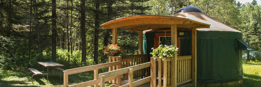 A yurt with a wheelchair-friendly ramp access and a picnic table.