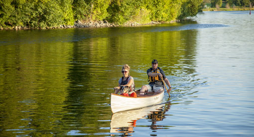 A couple canoes with their dog at Rideau Canal National Historic Site.