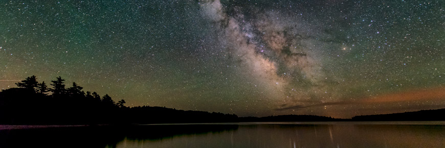 The Milky Way shines over Kejimkujik Lake at night.