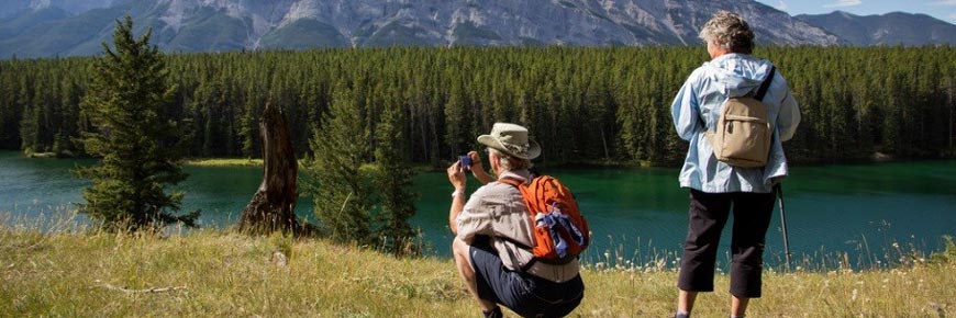 Two people looking at something in the distance. One is taking a photograph.