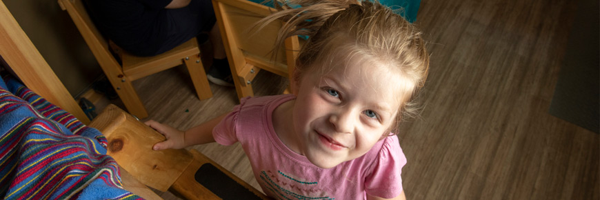 A young girl climbing on a bed in an oTENTik.