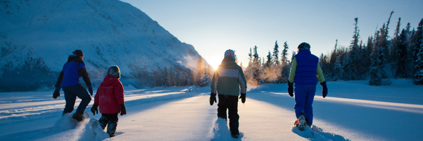 Une famille s’amuse en raquettes au parc national Kluane.