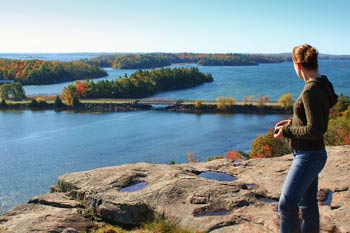 A woman admires the islands and the St. Lawrence River from a lookout on the Lookout Trail.