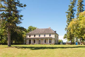 Le presbytère St. Andrew’s entouré d’arbres verts lors d’une journée d’été.