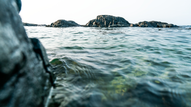 Wide view of Lake Superior from the water, with distant shoreline and open sky.