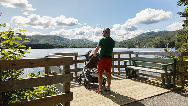 Une personne avec une poussette sur le sentier du lac Freshwater au parc des Hautes-Terres-du-Cap-Breton.