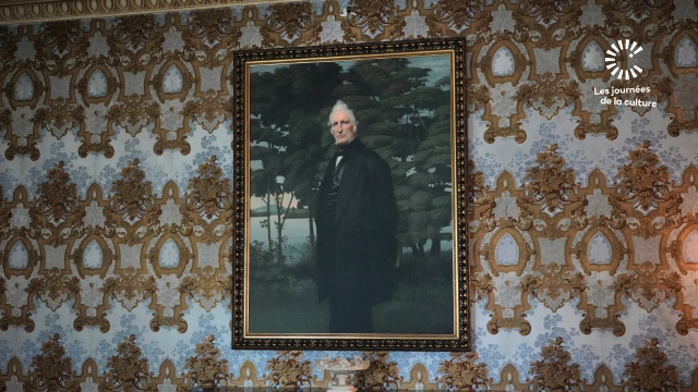 A framed photo of Joseph Papineau on a wall with wallpaper