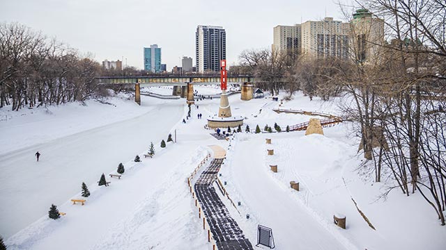 A skater on the frozen river bordering The Forks National Historic Site.