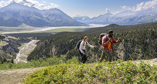 Two visitors on the Sheep Creek Trail, with mountains in the background in Kluane.