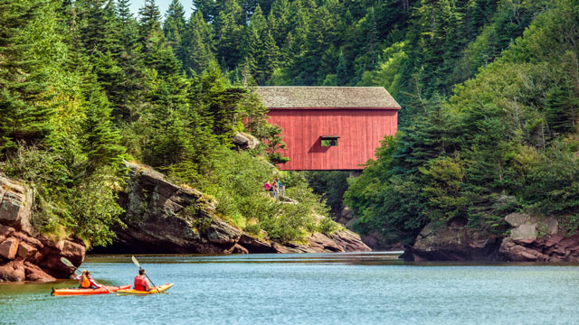 A couple kayaking near the covered bridge Wolf Point in the Bay of Fundy.