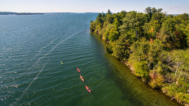 Aerial view of 4 kayaks along the shore at Thousand Islands National Park.