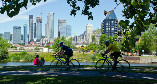 Two cyclists bike along the Lachine Canal. 