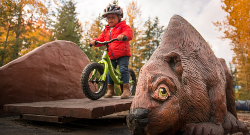 A child has fun on a ramp in the Beaver Lodge kids’ Bike Park. 