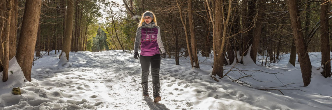 A person hikes in winter Rouge National Urban Park.