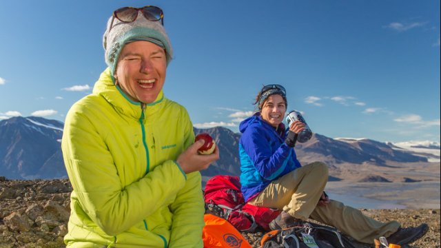  Two visitors have a snack while taking a break during their day hike near Tanquary Fiord in Quttinirpaaq National Park.