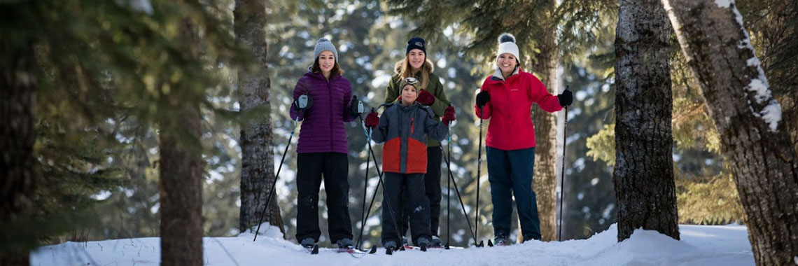 A group of four cross-country skiers pose in Prince Albert National Park.