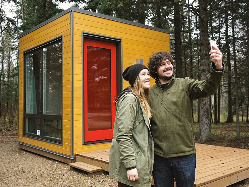 A couple takes a selfie in front of a MicrOcube.