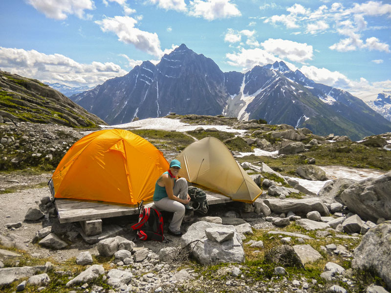 Une femme fait du camping dans le secteur Prés Hermit, un paysage montagneux.