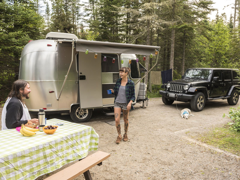Two visitors with their dog and their RV at Hattie Cove Campground in Pukaskwa National Park.