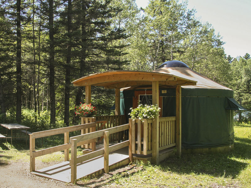 A universal access ramp leads to the entrance of a yurt.