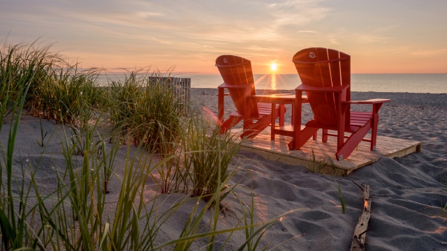 Two red chairs at Kellys Beach during sunrise.