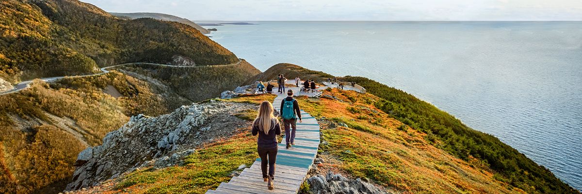 Visitors on the Skyline Trail with the ocean in the background in the Cape Breton Highlands.