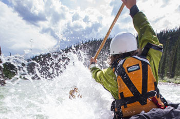 A visitor canoeing whitewater