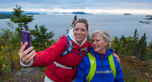 Mother and daughter snapping pictures of Lloyd's look-off while taking a break from hiking, near Township of Red Rock.