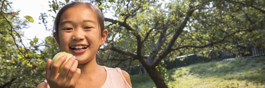 A young girl eats an apple