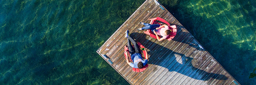 Deux visiteurs sur des chaises sur un quai du parc national des Mille-Îles