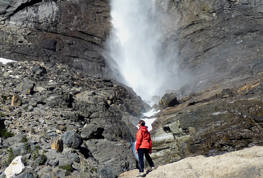 A visitor admires the Takakkaw Falls from below