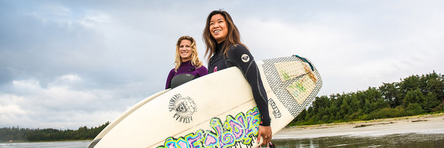 Two young women head out for a surf session on Long Beach