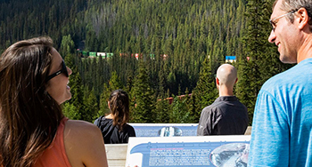 Visitors watch trains at the Spiral Tunnels viewpoint at Kicking Horse Pass.