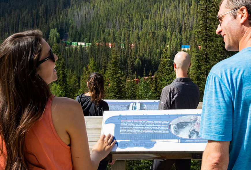 Visitors watch trains at the Spiral Tunnels viewpoint at Kicking Horse Pass.