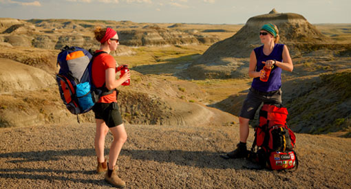 Deux jeunes femmes prennent une pause et boivent de l'eau lors de leur expédition de randonnée pédestre dans la Valée des 1000 diables.