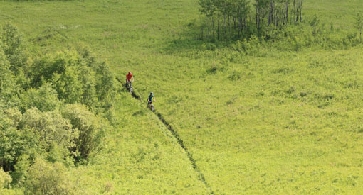 Visitors ride their bikes on the Valleyview Trail network in Prince Albert National Park.