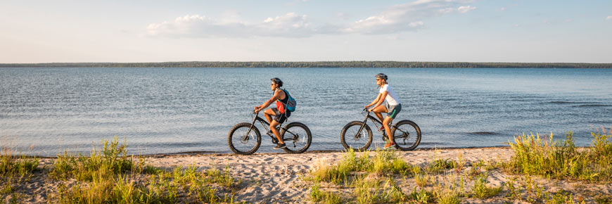 Des visiteurs font du vélo à pneus surdimensionnés sur le sentier du Lac-South.