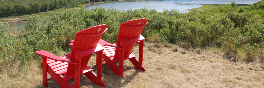 Two red chairs and a family in front of the South Saskatchewan River valley.