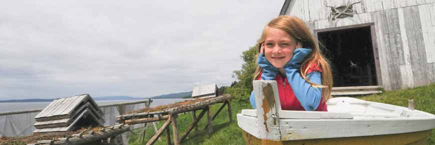Une jeune fille dans une chaloupe au site historique de Grande-Grave.