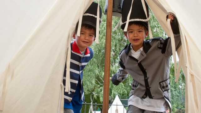 Enfants visiteurs en costume d’époque dans une tente de la reconstitution de la bataille de 1812.