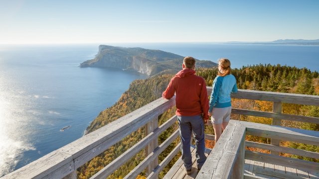 Two adults watching the cliffs and the sea from an observation tower.