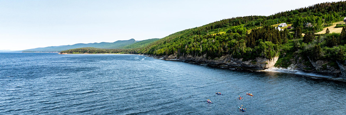 Kayakers in Gaspé Bay paddling along the south coast of Forillon National Park.