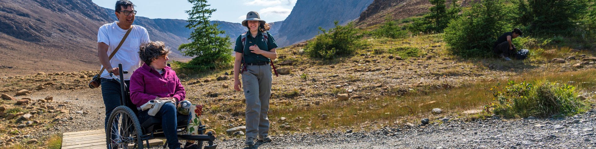 Une interprète de Parcs Canada guidant une visiteuse sur les Tablelands. La visiteuse utilise un fauteuil roulant tout terrain GRIT.